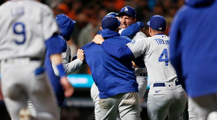 Oct 14, 2021; San Francisco, California, USA; Los Angeles Dodgers pitcher Max Scherzer (facing camera) is mobbed by teammates after defeating the San Francisco Giants in game five of the 2021 NLDS at Oracle Park.